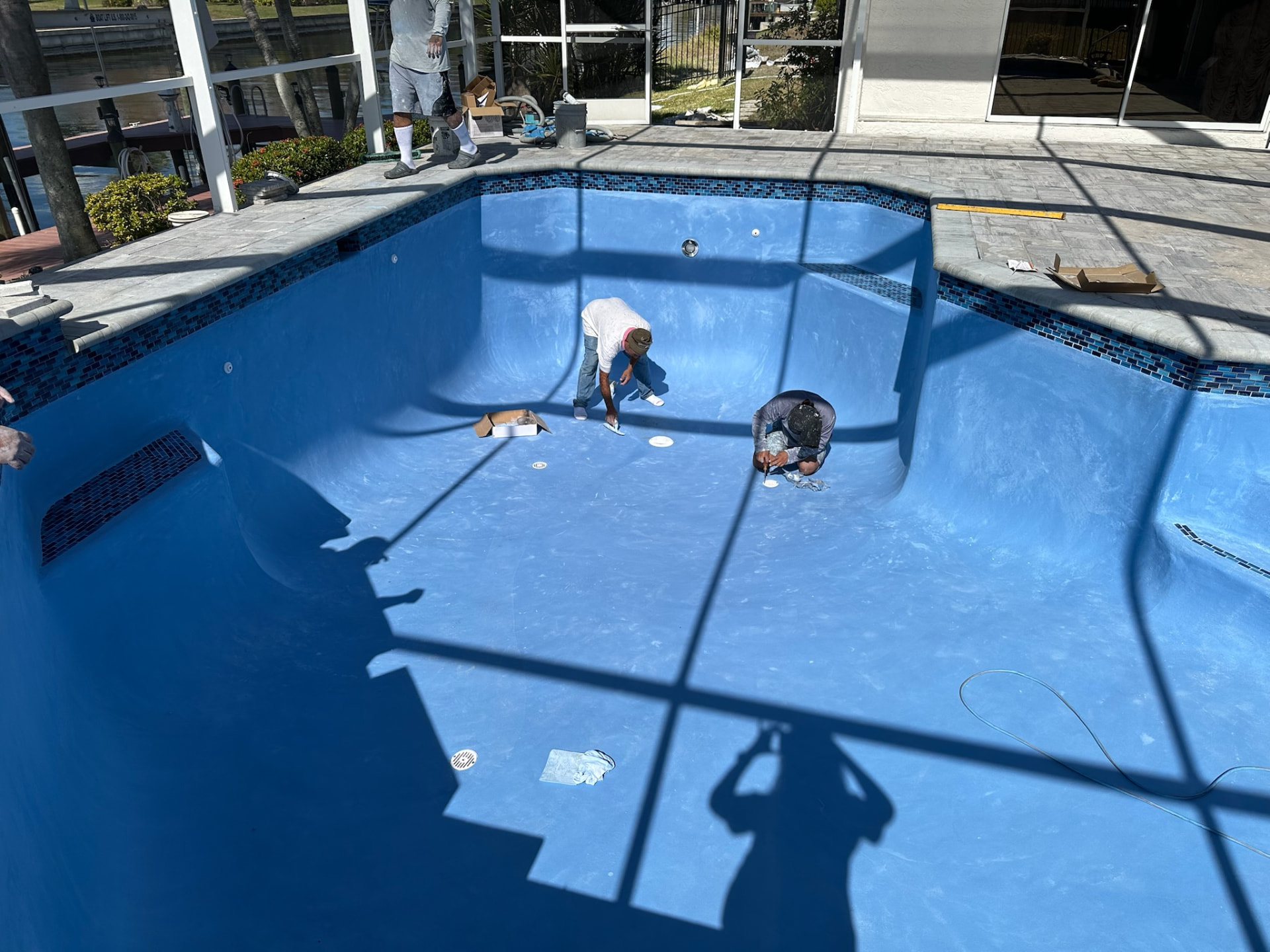 Eden crew hand-finishing a freshly resurfaced pool interior